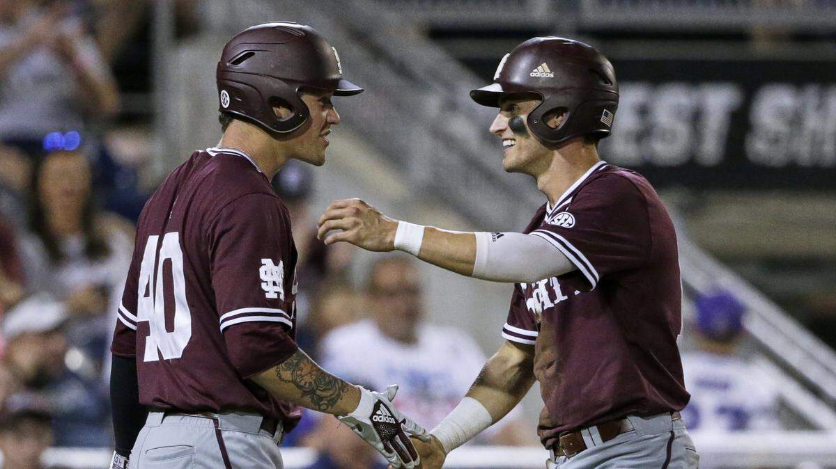 Mississippi State’s Jake Mangum, right, celebrates with Elijah MacNamee (40) after he scored against Louisville during the seventh inning of an NCAA College World Series baseball game in Omaha, Neb., Thursday, June 20, 2019. (AP Photo/Nati Harnik)