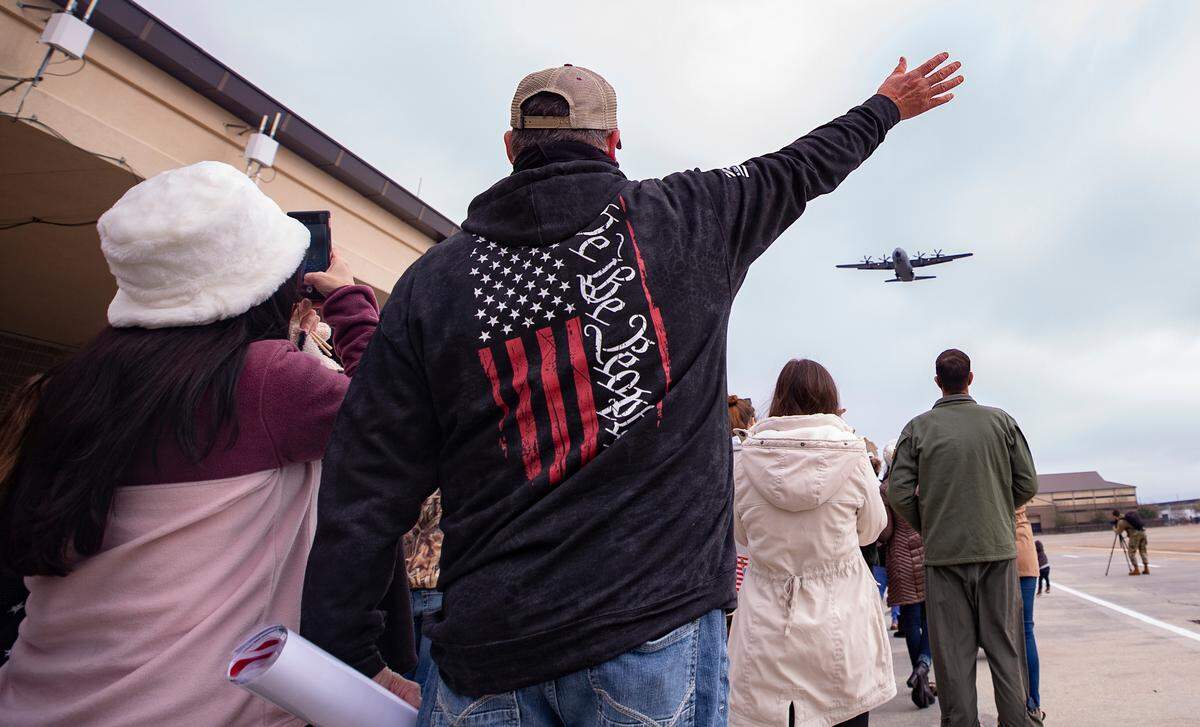 Family members wave to the C-130J planes carrying their reserve citizen airmen back to Keesler Air Force Base in Biloxi, Mississippi, Saturday, Feb. 13, 2021. The airmen from the 815th Airlift Squadron and other members throughout the 403rd Wing were deployed to Southwest Asia in November 2020. 