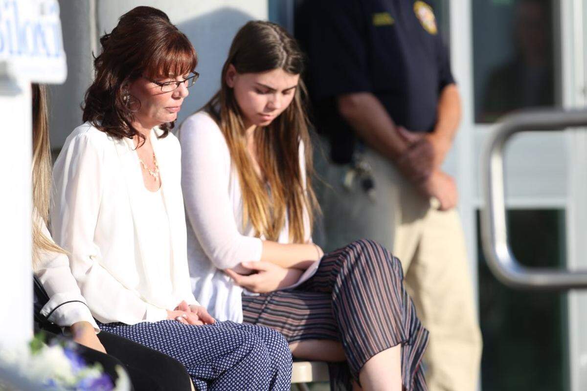 Pamela McKeithen, left, bows her head during a prayer vigil for her husband, slain officer Robert McKeithen, on Tuesday, May 7, 2019, at the Biloxi Police Department.