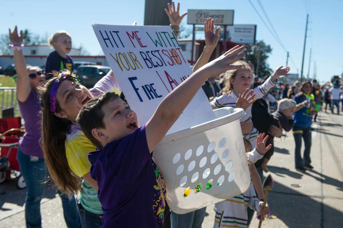Revelers hold a basket for catching beads and other items krewes toss during the Krewe of Nereids Mardi Gras parade on Highway 90 in Bay St. Louis on Sunday, Feb. 12, 2023.