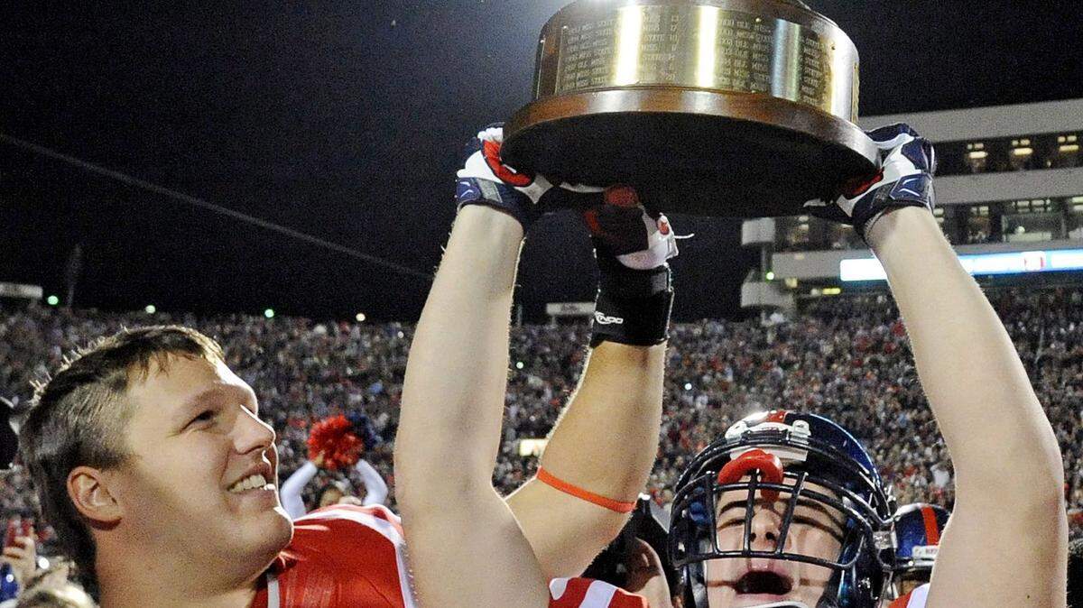 THOMAS GRANING/ASSOCIATED PRESS 
 Ole Miss' John Youngblood and Walker Sturgeon celebrate with the Egg Bowl trophy after beating Mississippi State in 2014. Youngblood is the recipent of the Chucky Mullins Award.