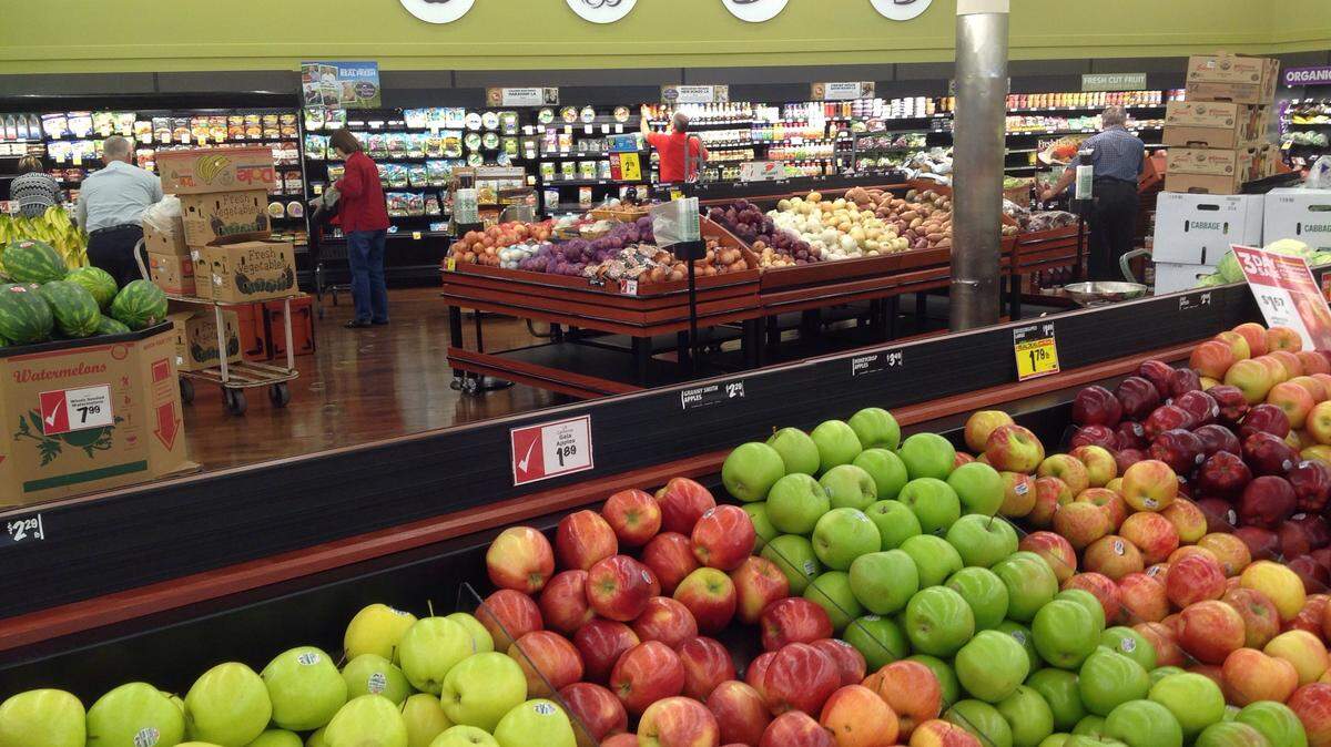 MARY PEREZ/SUN HERALD 
 Shoppers make selections in the produce department of the Orange Grove Winn-Dixie store on U.S. 49 in Gulfport. Winn-Dixie parent company has made a commitment to buy local produce whenever possible.