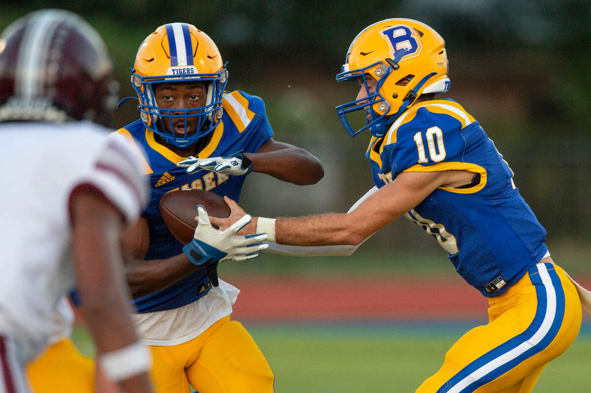 Bay High’s Xander Ladner passes the ball off to Jaylen Antoine during a game between Bay High and Long Beach at Tiger Stadium in Bay St. Louis on Friday, Sept. 13, 2024.