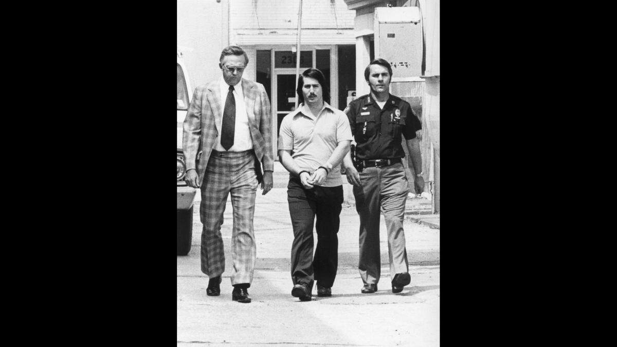 Police escort convicted killer and death row inmate Richard Gerald Jordan in the aftermath of his arrest in the 1976 kidnapping and killing of Edwina Marta. Jordan remains on death row after losing the latest of many appeals.