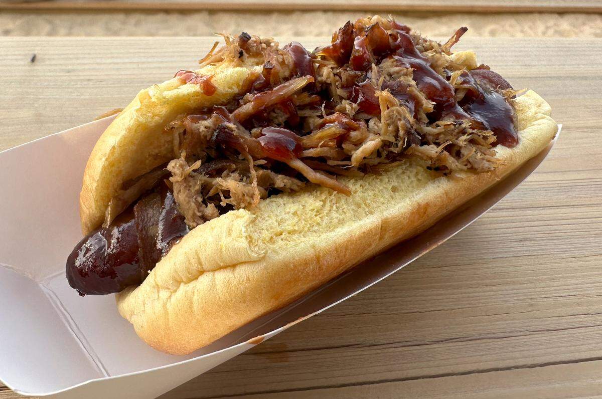 The pig out dog homestand special, which features a hot dog wrapped in bacon and topped with pulled pork, at the Shuckers Ballpark in Biloxi on Thursday, May 23, 2024. The hotdog can be purchased at the stadium’s new Catch of the Day concession stand.
