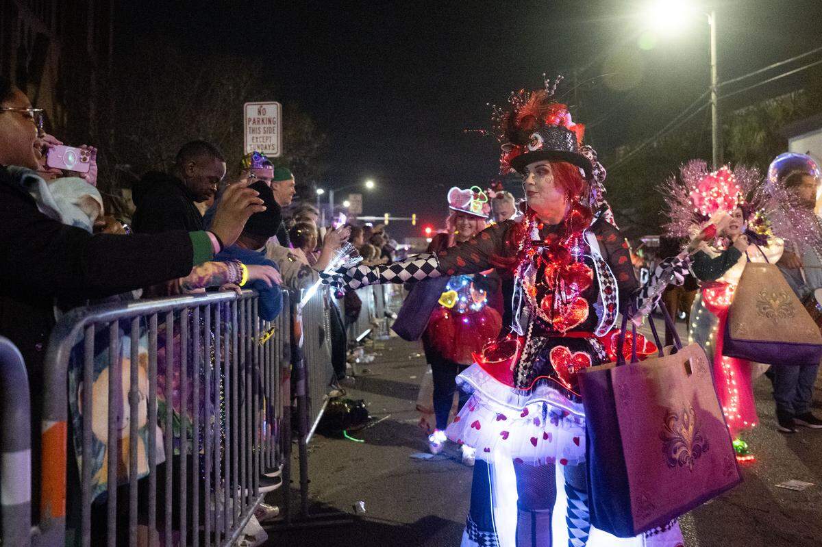 Candy and Mardi Gras beads are passed out by parade participants during the Krewe of Neptune parade in Biloxi on Saturday, Feb. 14, 2026.