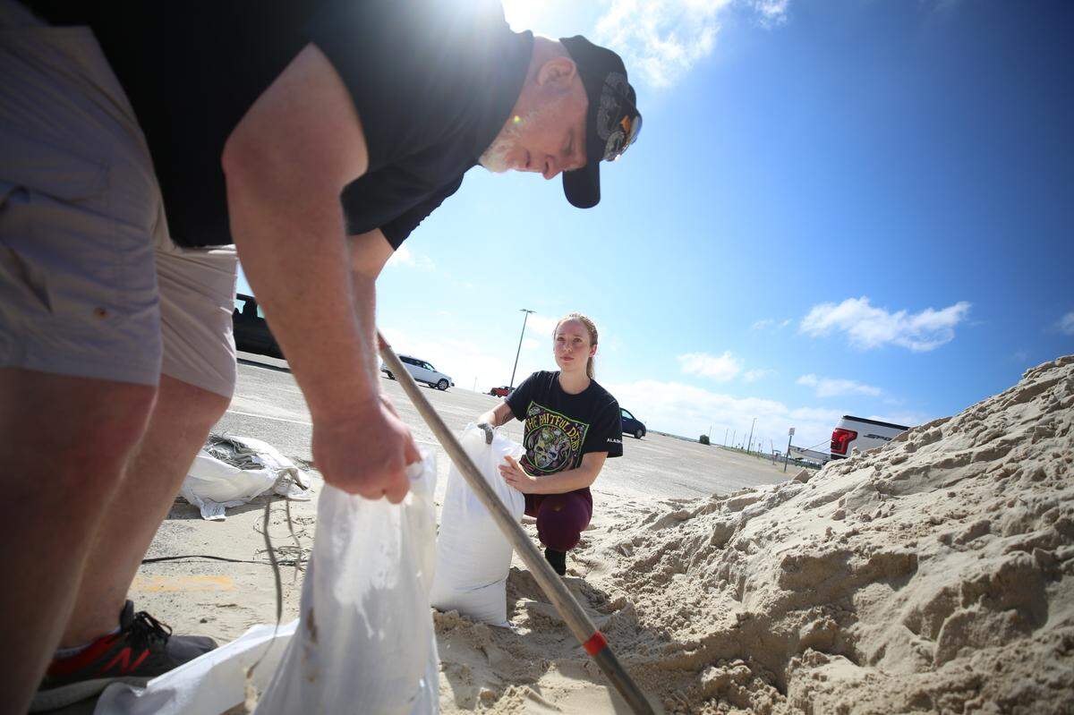 Meghan Roberts holds a sand bag as Timothy Lundy helps to it with sand. The two helped one another fill more than 15 at the Gulfport sand pile along Highway 90 to prepare for Laura as the storm makes its way towards the Mississippi Coast September 13, 2020.