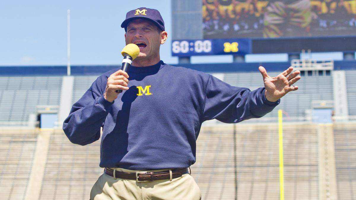 Michigan head coach Jim Harbaugh introduces his team to fans and media at Michigan Stadium, during the NCAA college football team's annual media day in Ann Arbor, Mich., Thursday, Aug. 6, 2015. (AP Photo/Tony Ding)