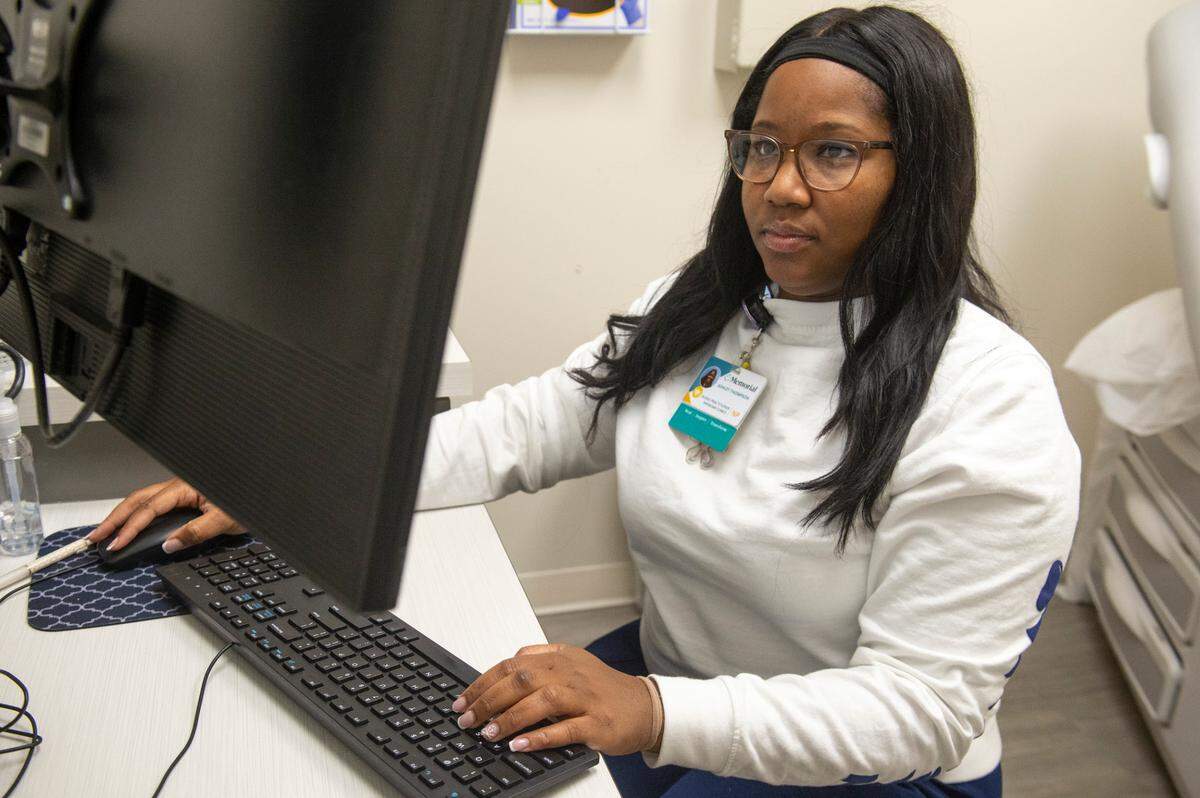 Nurse practitioner Ashley Thompson works at a computer at a Memorial Health walk-in clinic in Gautier on Wednesday, Jan. 15, 2025. Thompson says she has seen an increase in norovirus patients recently.