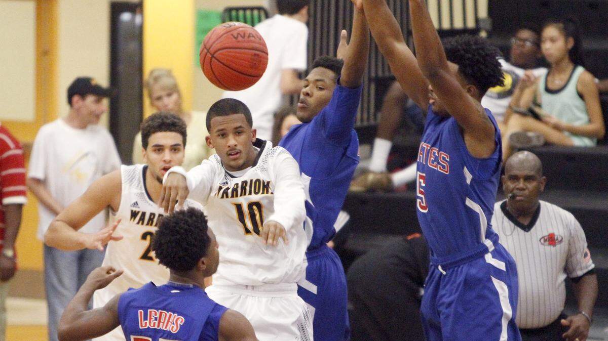 TIM ISBELL/SUN HERALD 
 D'Iberville guard Nick Jenkins gets the ball out of the lane after he was surrounded by three Pass Christian Pirates, Friday, Dec. 11, 2015.