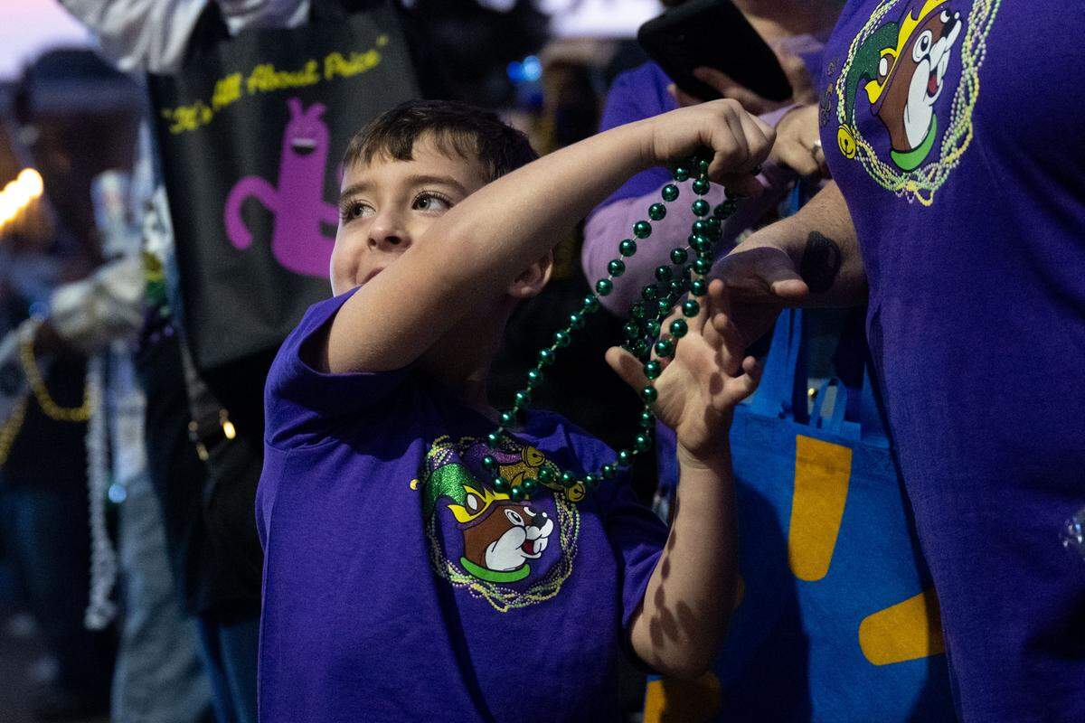 Joseph Simmons plays with a string of Mardi Gras beads received from a float during a 12th Night Celebration in Biloxi on Monday, Jan. 5, 2026.