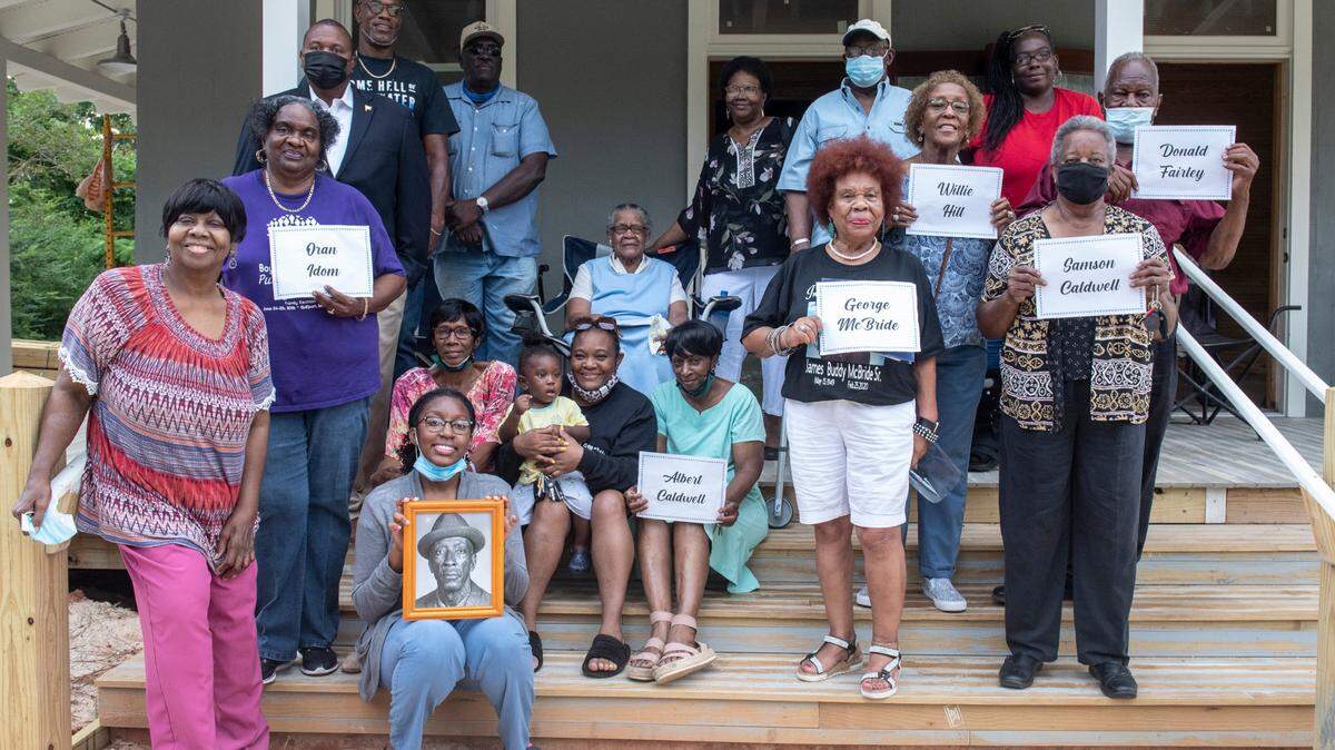 Descendants of timber industry workers in Turkey Creek pose for a portrait on the steps of the renovated paymaster’s office from the Phoenix Naval Stores plant on Wednesday, July 28, 2021. The restored office, the only building to survive a 1943 explosion at the plant, will soon be dedicated as a community center and museum.