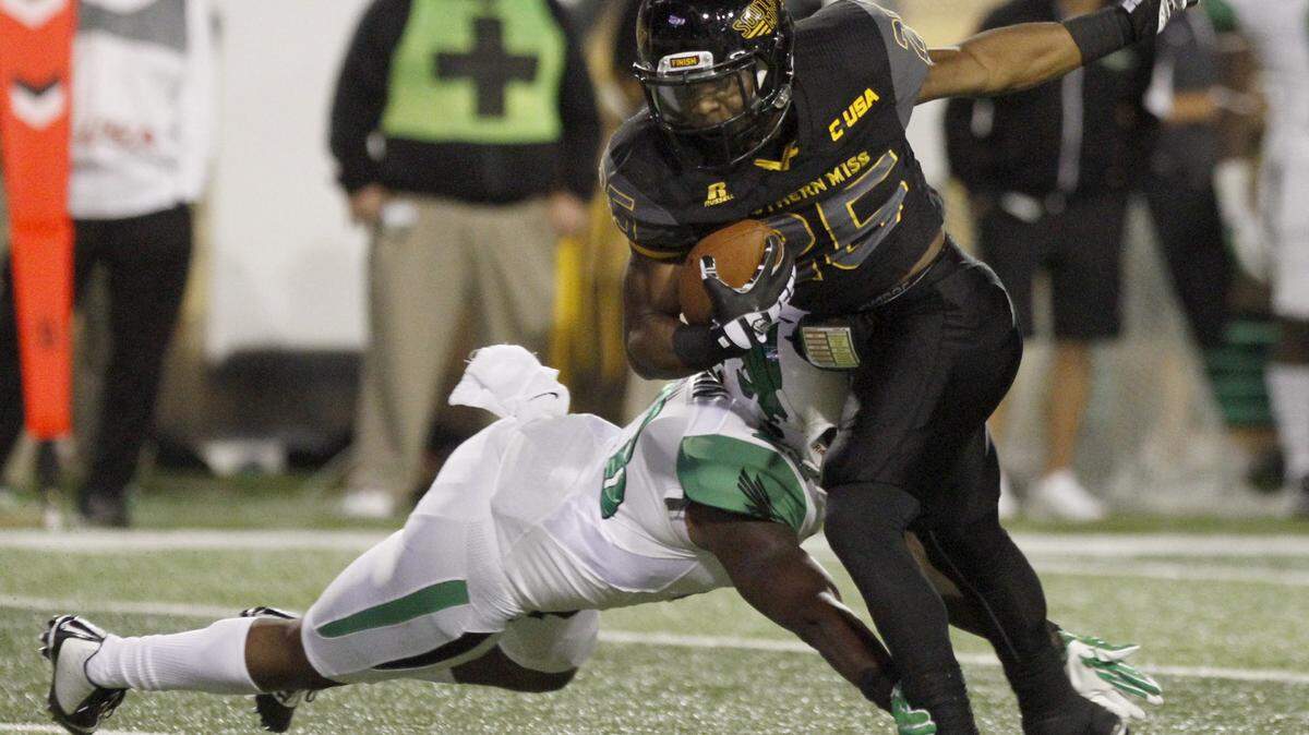 TIM ISBELL/SUN HERALD 
 Southern Miss running back Ito Smith tries to elude a diving North Texas defensive back on Oct. 3 in Hattiesburg.