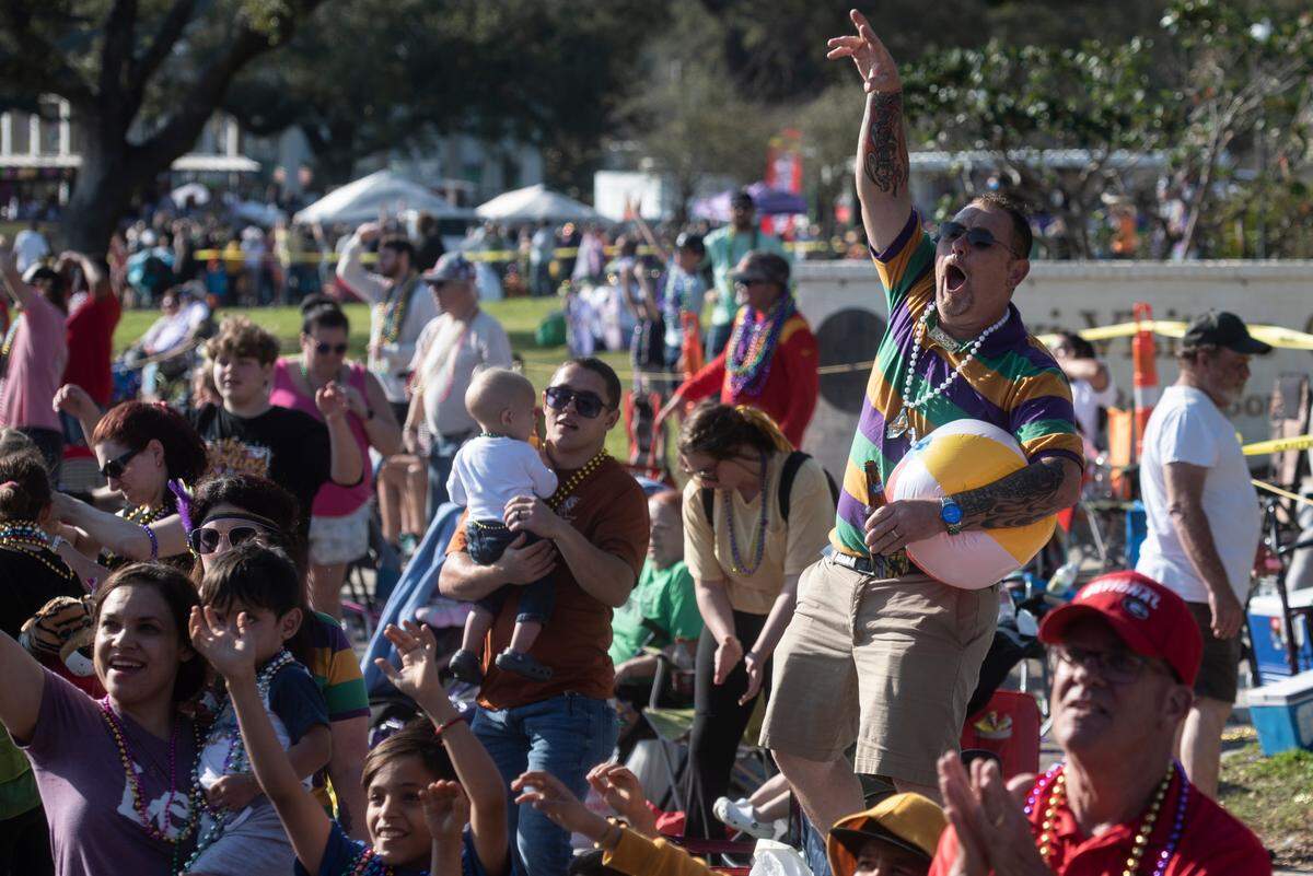Paradegoers cheer for beads during the Gulf Coast Carnival Association Mardi Gras parade in Biloxi on Tuesday, Feb. 21, 2023.
