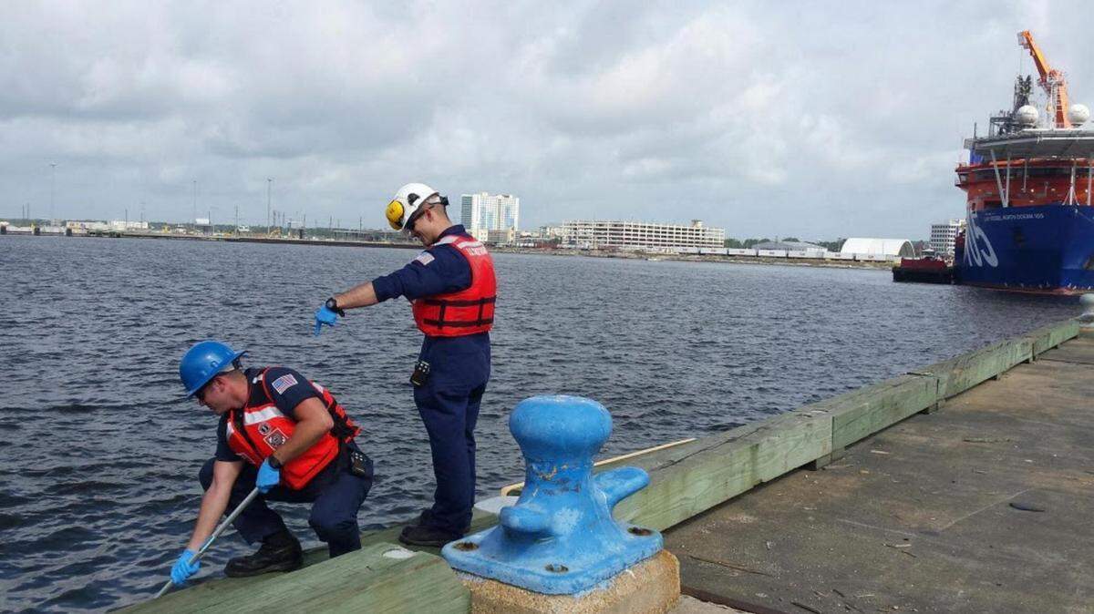 Petty Officer 3rd Class Chris Roble and Petty Officer 2nd Class Ronnie Lucas assess the site of a diesel spill in Gulfport Harbor in Gulfport, Mississippi, June 15, 2016. The Coast Guard is working with state and local agencies in response to the spill. U.S. Coast Guard photo by Lt.j.g. Elizabeth Tatum