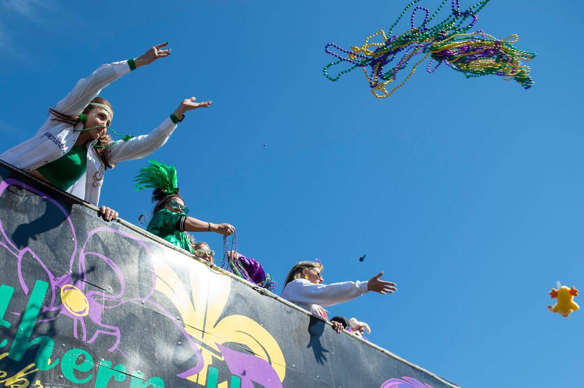 Float riders toss beads to the crowd during the Gulf Coast Carnival Association Mardi Gras Parade in Biloxi on Tuesday, March 1, 2022.