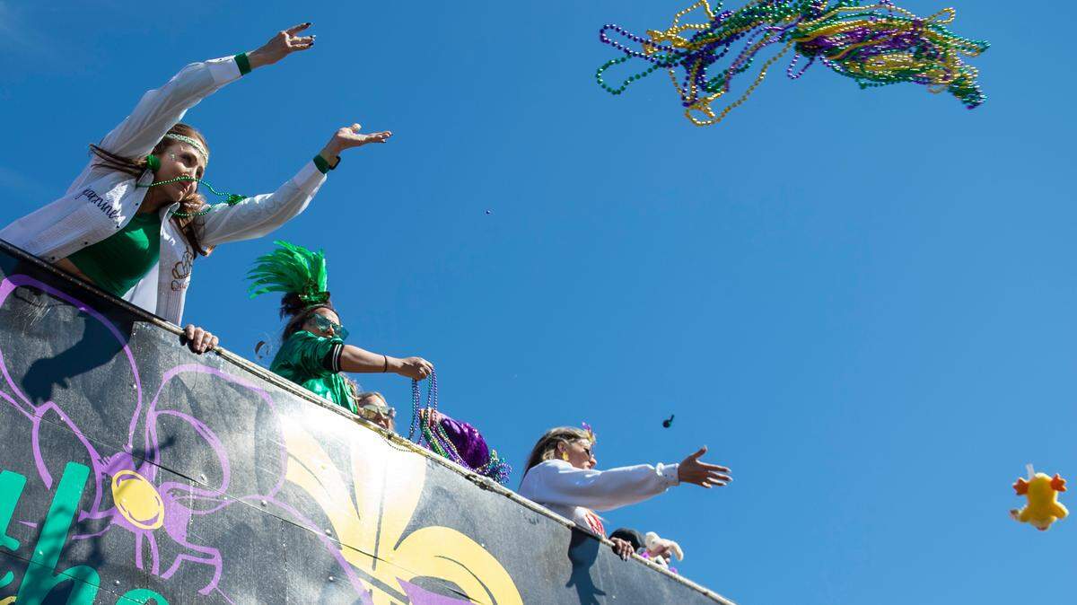 Float riders toss beads to the crowd during the Gulf Coast Carnival Association Mardi Gras Parade in Biloxi on Tuesday, March 1, 2022.