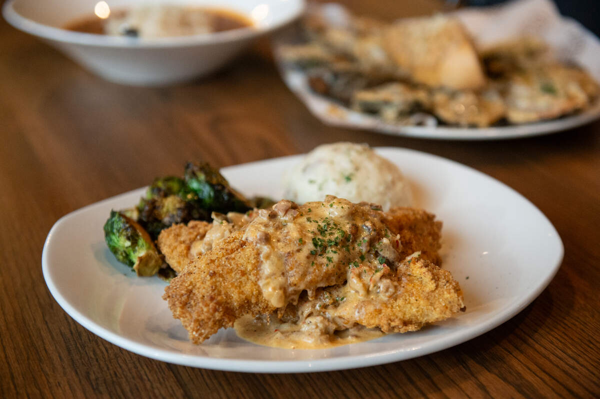 The catfish Napoleon, topped with crawﬁsh andouille cream sauce and served with Brussel sprouts and mashed potatoes at Coterie Restaurant and Oyster Bar in Long Beach on Thursday, Dec. 14, 2023.