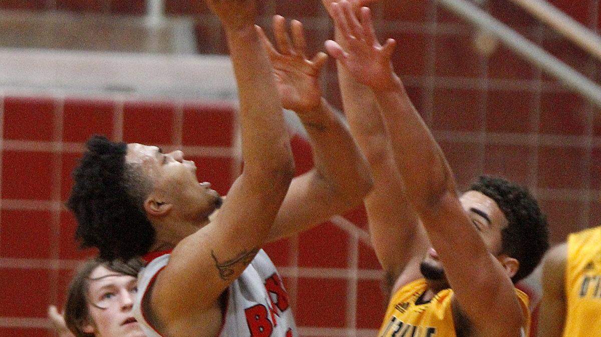 TIM ISBELL/SUN HERALD 
 Biloxi's Fred Ramsey-Thompson puts up a shot over D'Iberville's Evan Howard, Wednesday, Feb. 24, 2016.