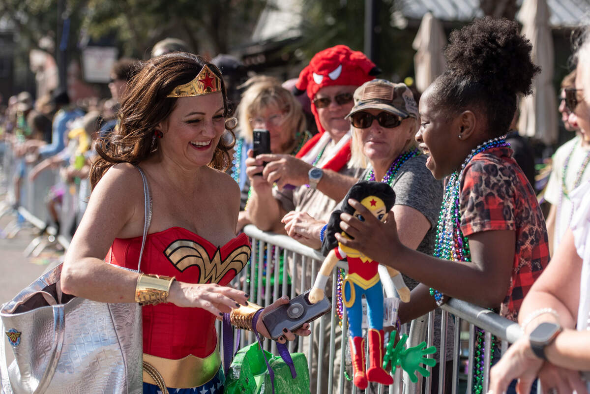 The Krewe of Wonder Women hands out Wonder Woman dolls during the Ocean Springs Elks Club Mardi Gras Parade in Ocean Springs on Saturday, Feb. 15, 2025.