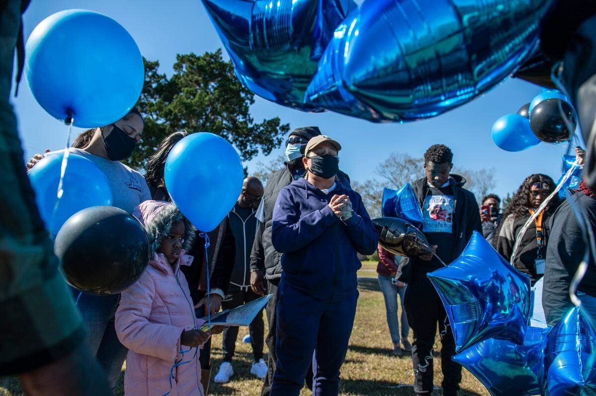 Tiffany McGary-Cyprian, 47, center, the mother of Corri Howard’s fiancé, leads a prayer during a balloon release in his honor on Monday, Jan. 17, 2022.