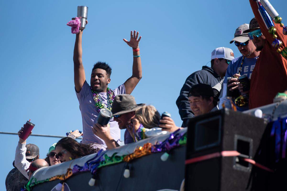Revelers ride on top of a float during the Krewe of Nereids Mardi Gras parade on Highway 90 in Bay St. Louis on Sunday, Feb. 12, 2023.