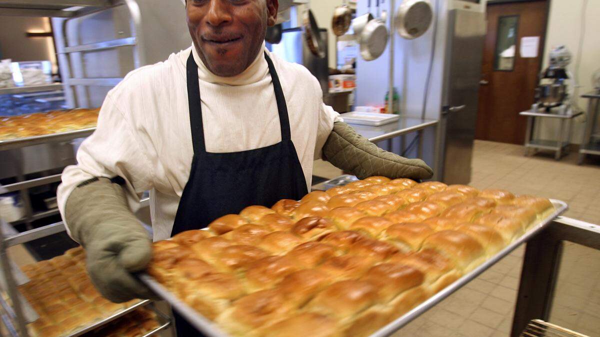 Johnnie Oliver, volunteer, serves a tray of hot rolls during a previous year's Thanksgiving meal at Feed My Sheep Soup Kitchen. Among several free holiday meals in South Mississippi this week, this year's annual Thanksgiving lunch at Feed My Sheep will begin at 11 a.m. Wednesday at 2615 19th St., Gulfport.