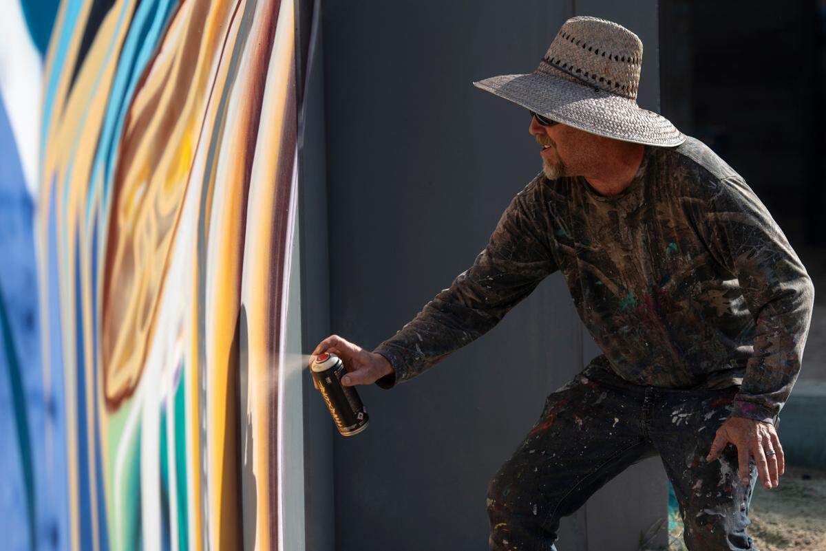 Artist Douglas Hoekzema, also known as Hoxxoh, works on a mural he is painting on the parking garage at the new OS 1515 development in downtown Ocean Springs on Tuesday, Oct. 29, 2024.