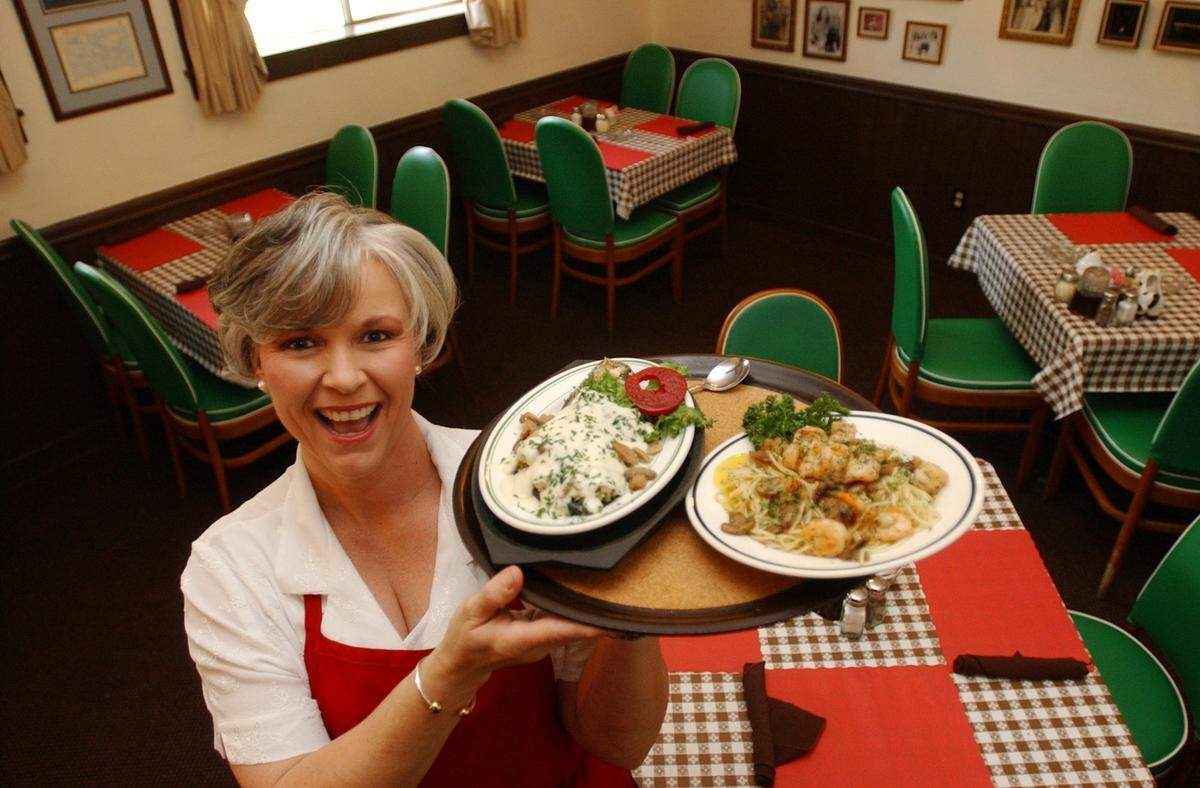 Dining room manager Debbie Cooper, an employee of Marguerite’s Italian Village in Pascagoula for 19 years, shows the MargueriteSpecial with sauteed  gulf shrimp and seasoned mushrooms and Eggplant Lamberto, which is stuffed  with gulf shrimp and Italian breaddressing, seasonings and topped with  Mornay sauce and mushrooms.