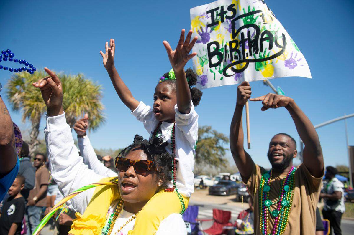 Parade attendees try to catch beads during the Jackson County Carnival Association Mardi Gras parade in Pascagoula on Saturday, March 1, 2025.