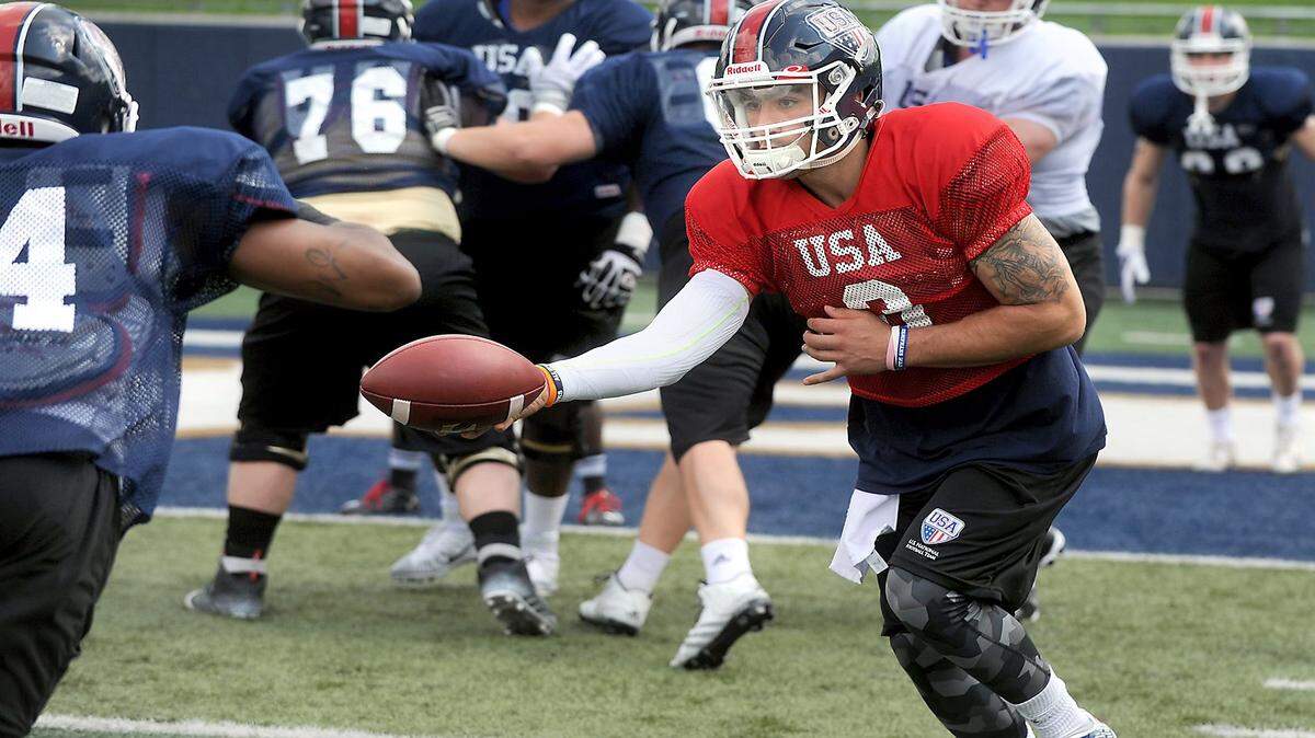 Quarterback Dylan Favre makes the hand-off during Team USA practice at the University of Akron.