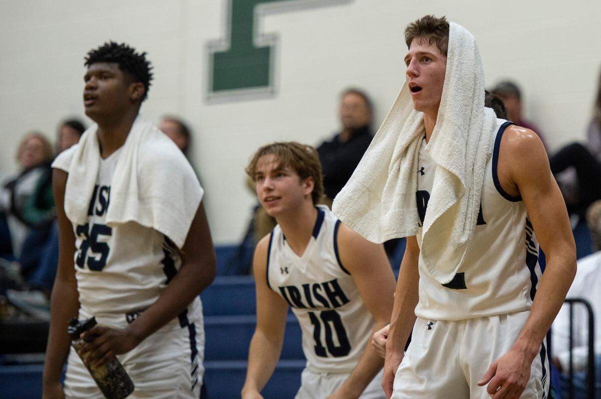 St. Patrick players Nick Krass, right, Rhett Jones, center, and Eric Davis cheer for their teammates from the sidelines during the fourth quarter of a game against Perry Central at St. Patrick Catholic High School on Thursday, Jan. 13, 2022.