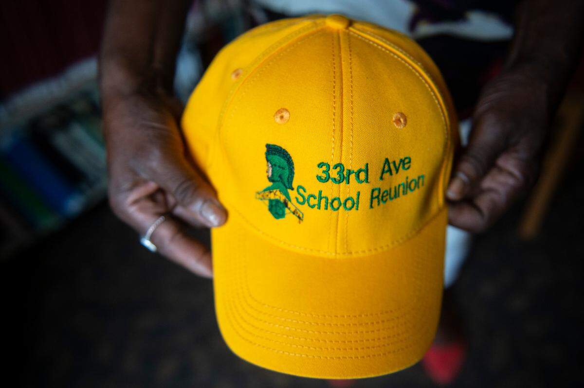 Gayle Tart holds a 33rd Ave School Reunion hat at East Biloxi Library on Saturday, July 31, 2021. 33rd Ave alumni are working to build an exhibit on the school that closed in 1969 when schools became integrated.