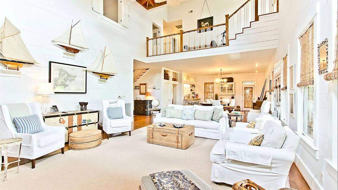 The property’s main house features an airy living and dining room area under a double-height ceiling.