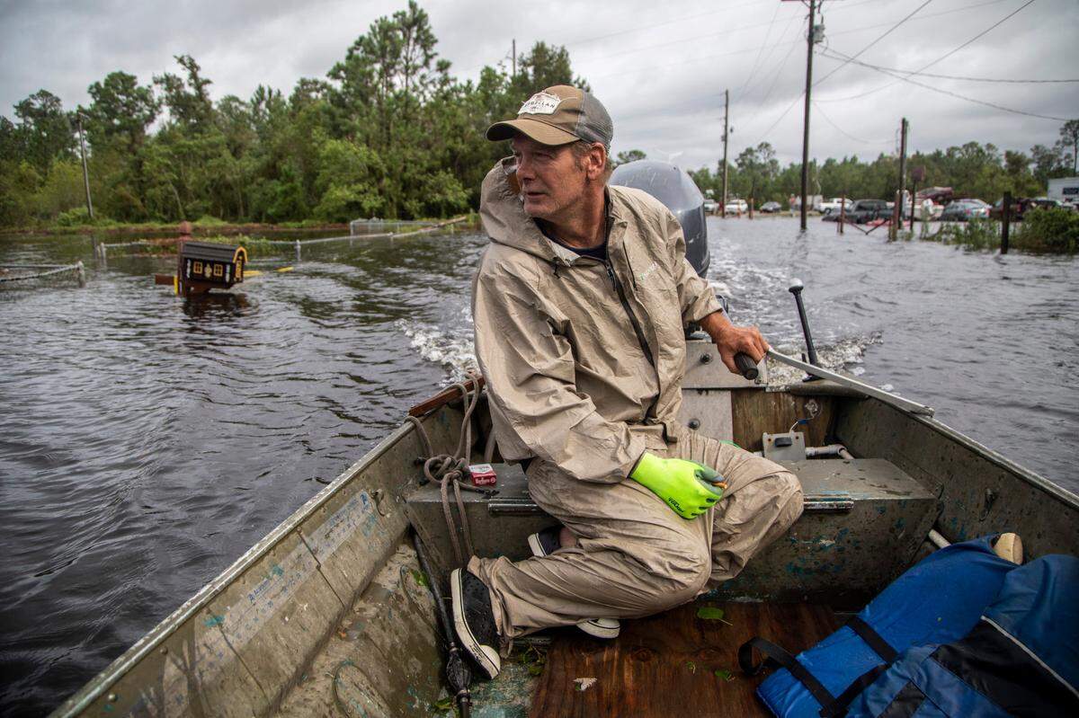 Eddie Gonzales pilots his boat through floodwaters in search of anyone who may need help in the Shoreline Park community in Bay St. Louis Monday, Aug. 30, 2021.