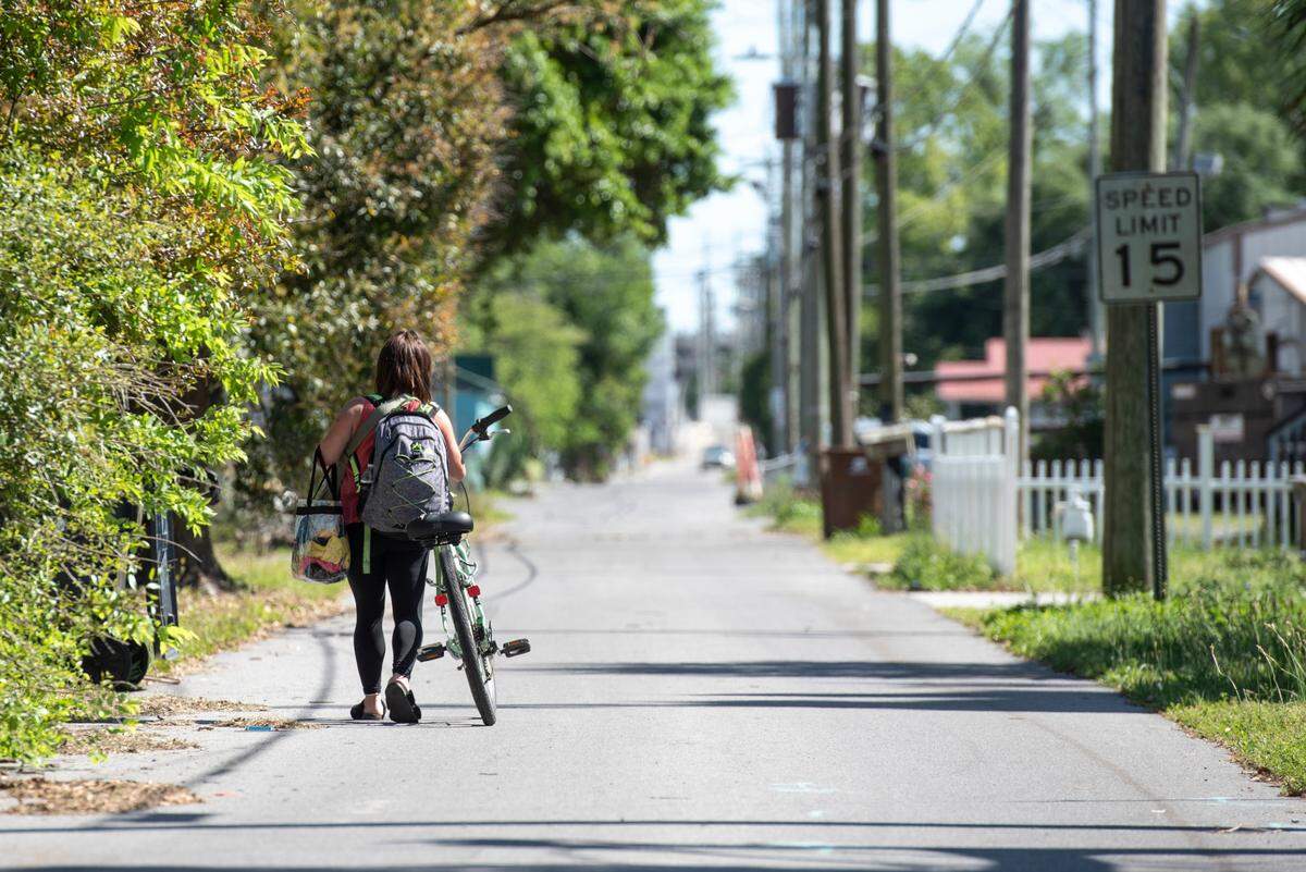 A woman experiencing homelessness walks along Couevas Street in Biloxi on Friday, April 11, 2025.