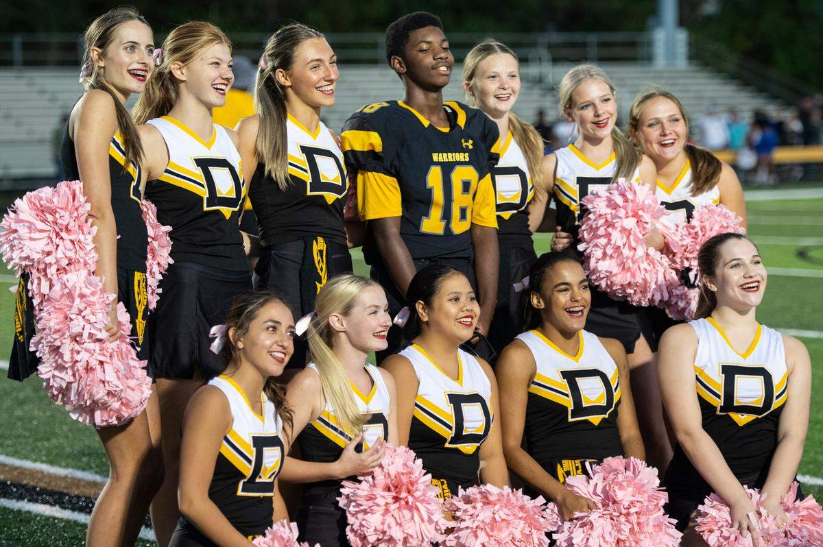 Tyler Hunter, the student manager for D’Iberville’s JV football team, poses with D’Iberville’s cheerleaders D’Iberville’s junior varsity team took on St. Martin at Warrior Stadium in D’Iberville on Monday, Oct. 9, 2023.