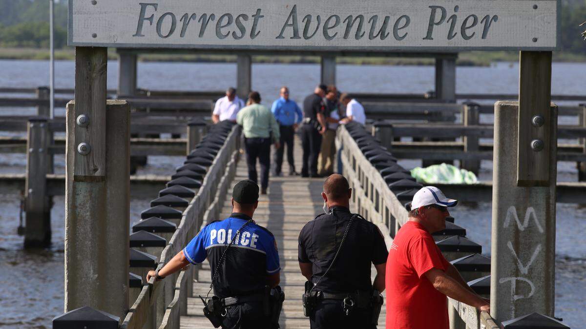 JUSTIN MITCHELL/SUN HERALD 
 Biloxi police and Department of Marine Resources officials recovered the body of a woman from Back Bay in Biloxi on Thursday, June 16, 2016. The body was covered with a sheet on the Forrest Avenue Pier until the coroner could arrive.