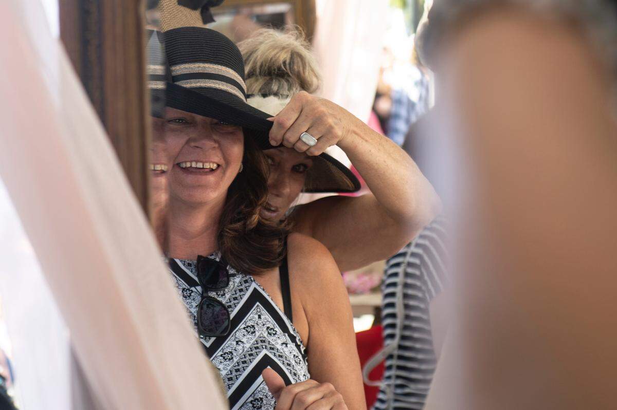 Laura Adams, a vendor selling hats, helps Kelly Mrozek, of Spanish Fort, AL, find the perfect hat during the Peter Anderson Festival in Ocean Springs on Sunday, Nov. 6, 2022.