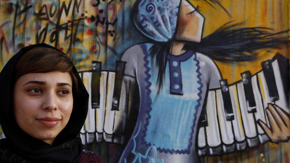 Artist Shamsia Hassani poses for a portrait on March 1, 2106 in front of her mural in Los Angeles. Hassani is an Afghani street artist who paints murals in Kabul. She's in LA this month for a Hammer Museum residency and recently painted a West Adams mural. (Francine Orr/Los Angeles Times/TNS)