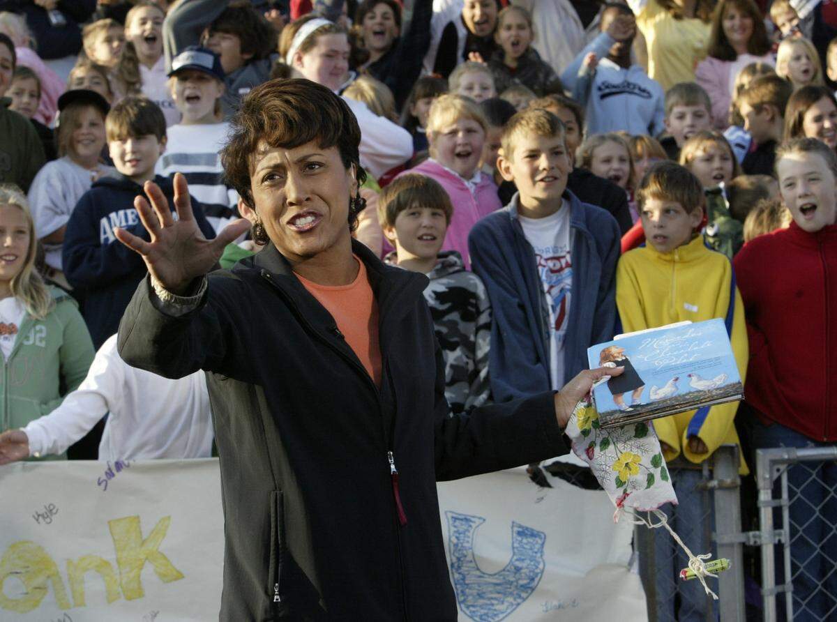 ABC Good Morning American co-host Robin Roberts, a former resident of Pass Christian, Mississippi, broadcasts live from the Bay High School football field after Hurricane Katrina. She is holding a sample of the candies given to students of Bay/Waveland Elementary schools who study each day in a nearby tent school. The tent school was established after Hurricane Katrina struck the Mississippi Gulf Coast and destroyed many of the schools. Roberts and other celebrities brought attention and assistance to South Mississippi after the storm.