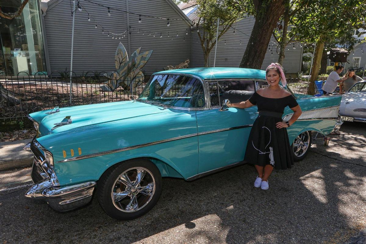 A young lady in her poodle skirt poses beside a vintage Chevrolet during the Ocean Springs Cruisin’ the Coast Block Party on Friday, Oct. 8, 2021.