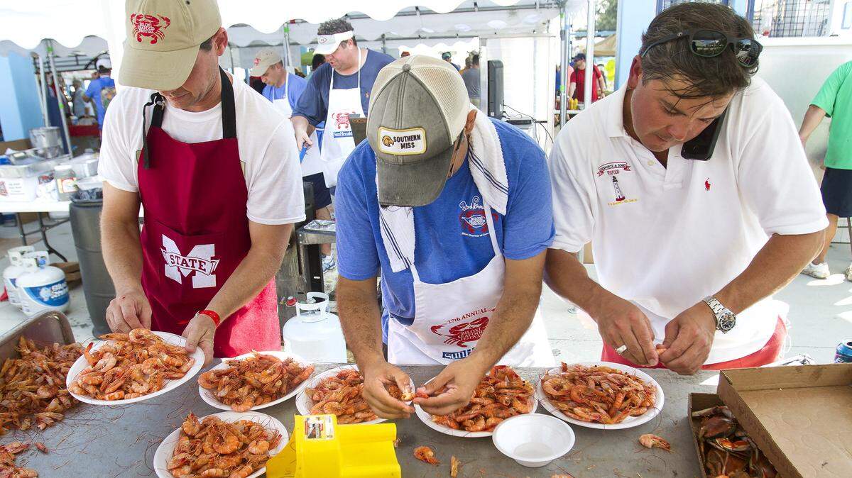 Bruce Marie, left, Sam Burke, center, and Sean Desporte plate boiled shrimp at the 33rd annual Biloxi Seafood Festival in 2014.