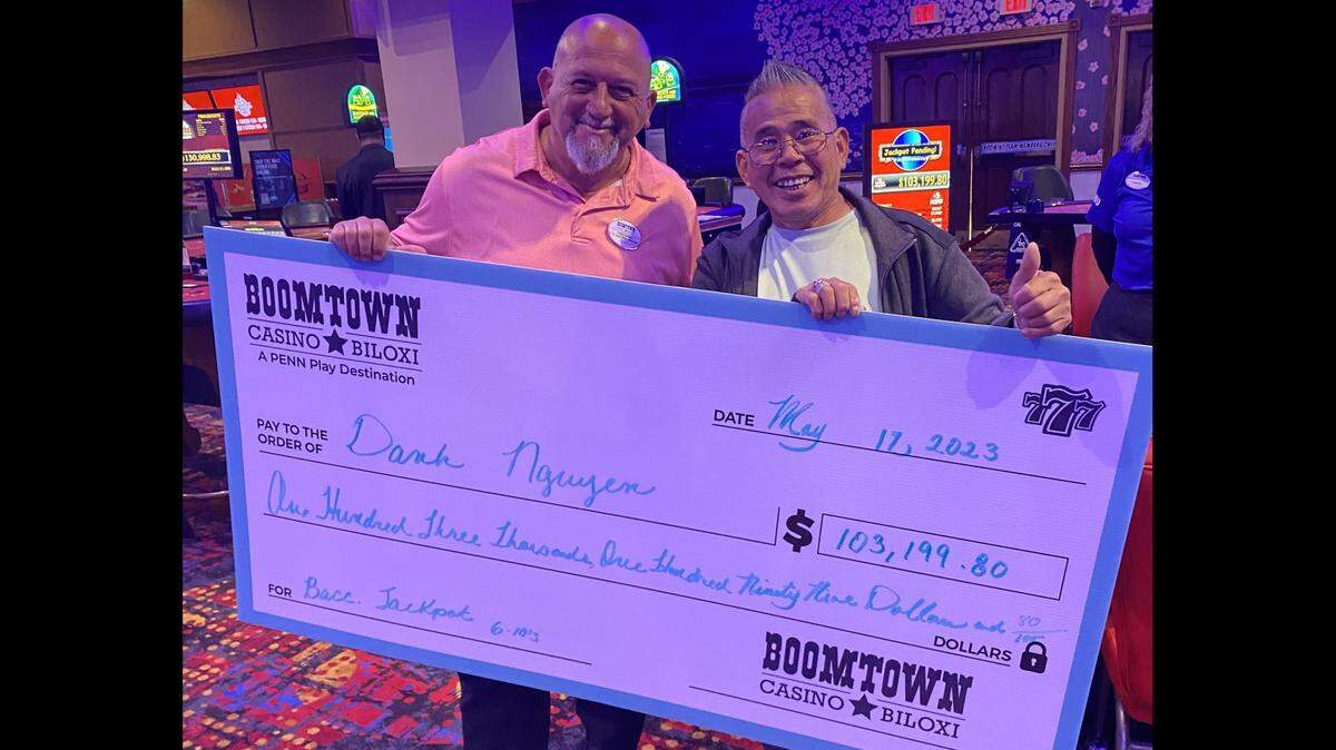 A Texas man, right, is joined by a staff member after he hit the jackpot on a progressive baccarat table game this week at Boomtown Casino Biloxi. The game is exclusively available in Mississippi at Boomtown, Hollywood Gulf Coast and Ameristar Casino Vicksburg.