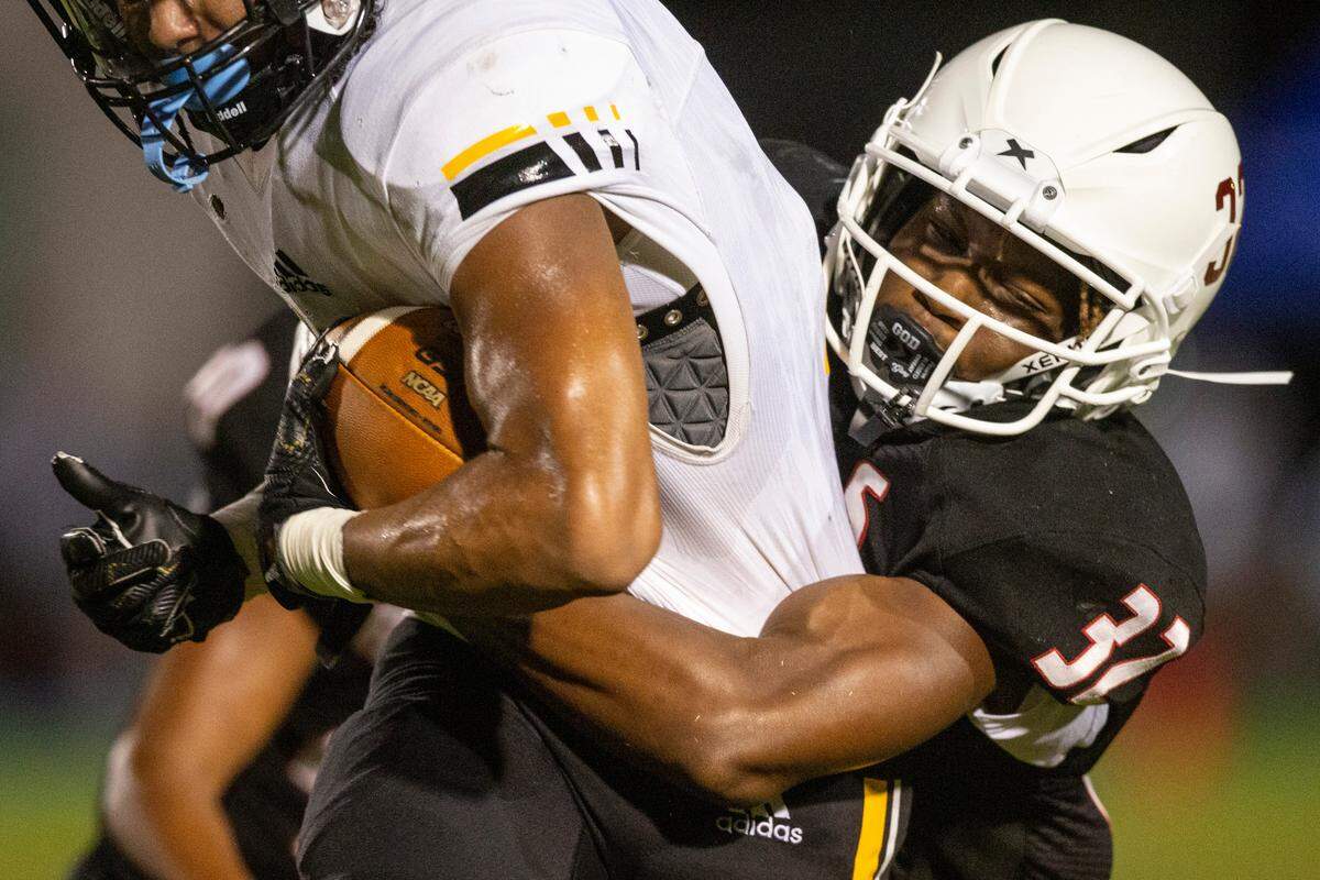 Harrison Central’s Ethan Brewer tackles Oak Grove’s ball carrier during a game against Oak Grove at Milner Stadium in Gulfport on Friday, Aug. 26, 2022.