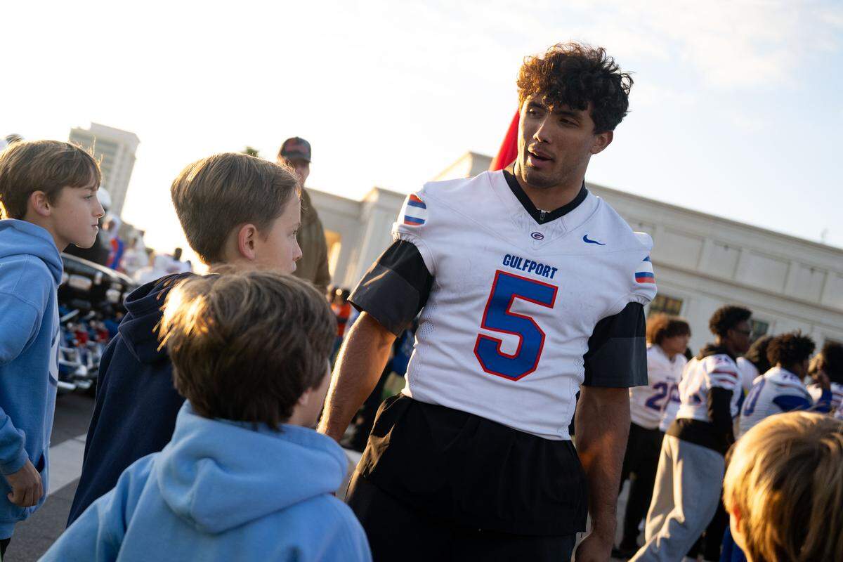 Gulfport running back Cooper Crosby talks with parade attendees during the Champions Christmas Parade in Gulfport on Monday, Dec. 8, 2025.
