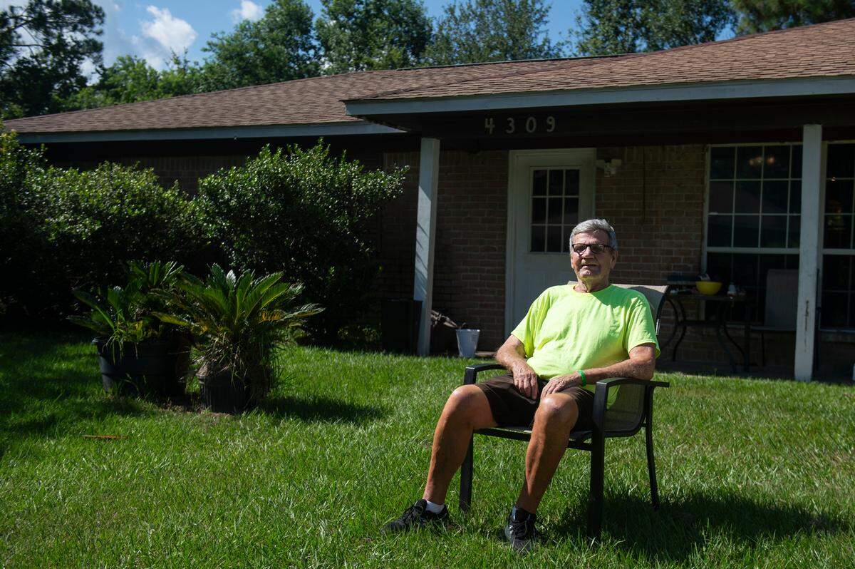 Bob Kiesau sits in his front yard in Ocean Springs on Monday, Aug. 5, 2024. According to Kiesau, his home is sinking, has a cracked foundation, cracked flooring, uneven doors and walls, as well as other issues, due to a drainage ditch eroding next to his property.