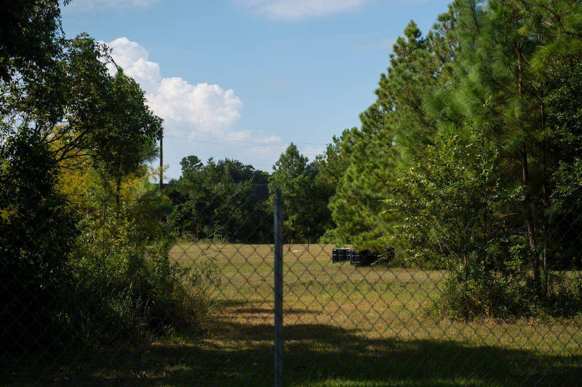 Black barrels sit on the site of a former optics manufacturing plant at the corner of Government Street and Pine Drive in Ocean Springs on Friday, Aug. 23, 2024. Mayor Kenny Holloway is hoping the property, long contaminated with chemicals, will be cleaned up for development of an upscale hotel.