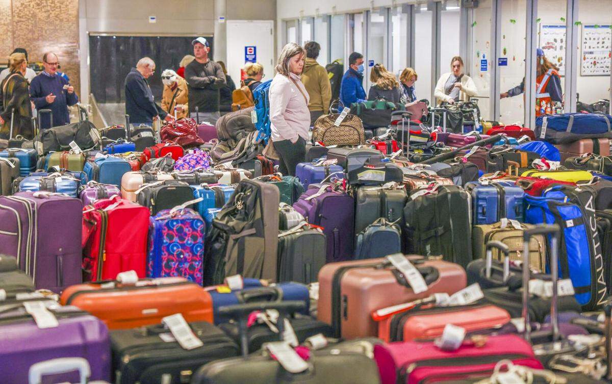 Travelers search for their luggage at the Louis Armstrong New Orleans International Airport in Kenner, La., Tuesday, Dec. 27, 2022.