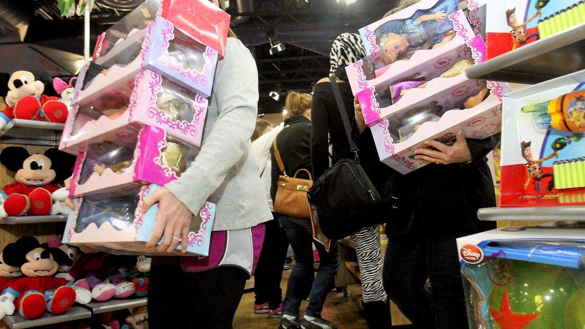 Original: Customers maneuver their way through the Disney Store with their arms full of items on Thursday, Nov. 22, 2012, at Gulfport Premium Outlets. 